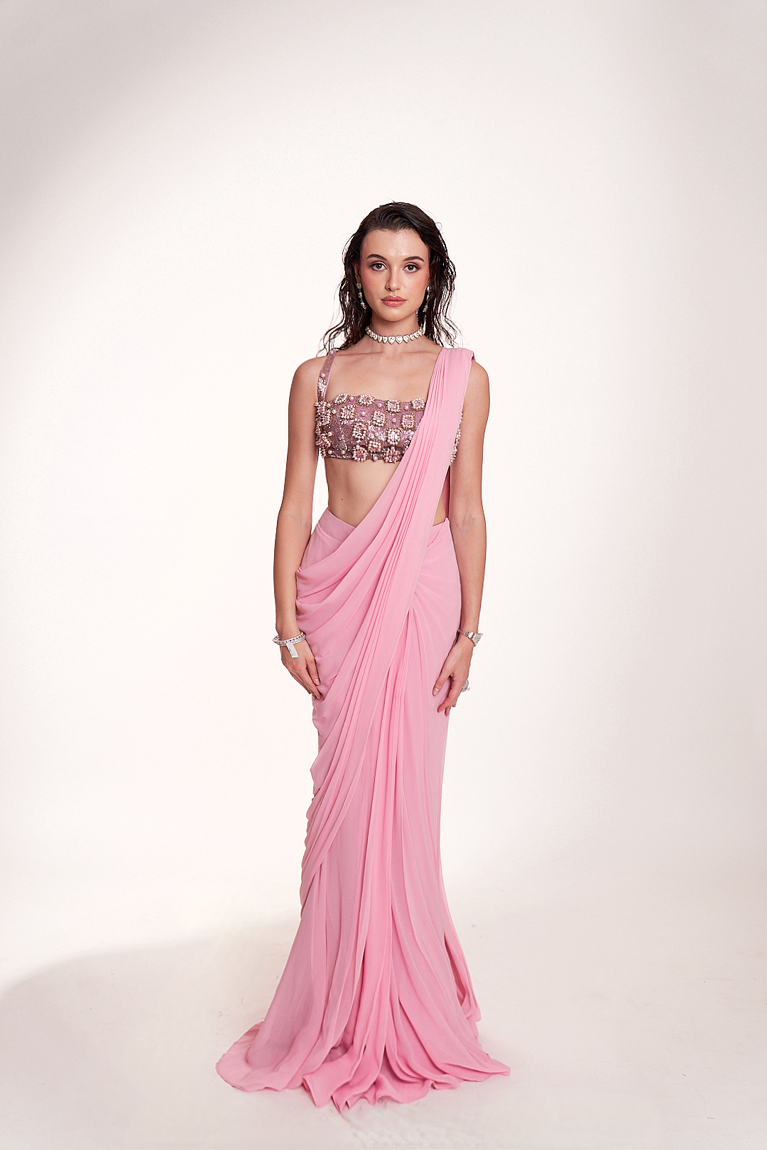 Pastel pink draped saree paired with an intricately embellished mirrorwork blouse