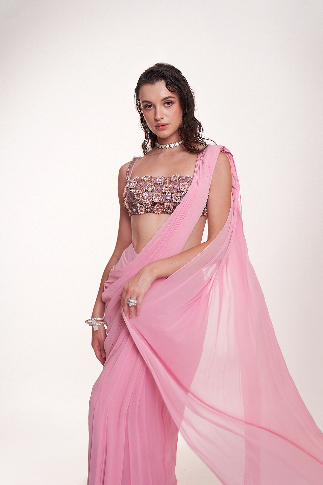 Pastel pink draped saree paired with an intricately embellished mirrorwork blouse
