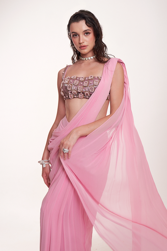 Pastel pink draped saree paired with an intricately embellished mirrorwork blouse