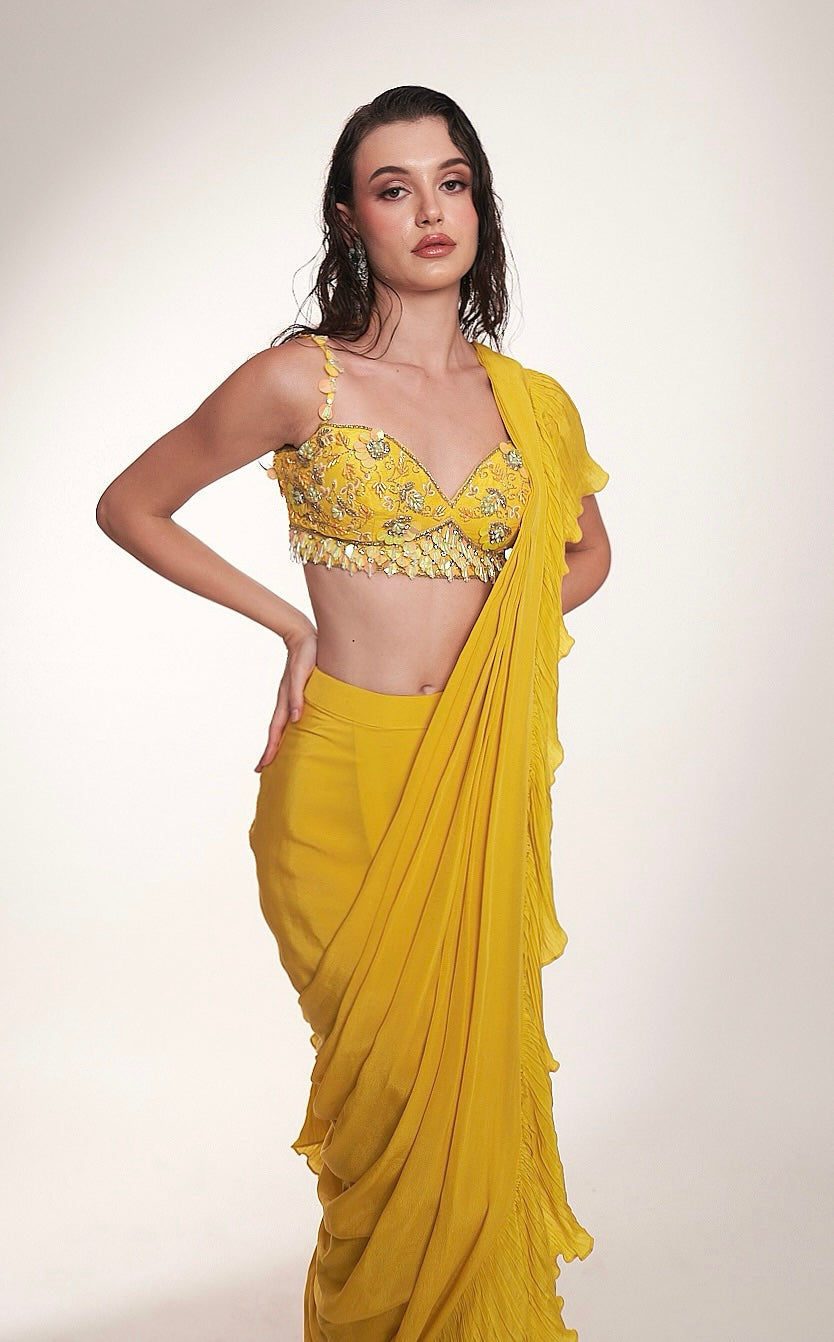 Bright yellow ruffled saree paired with an embellished bralette blouse