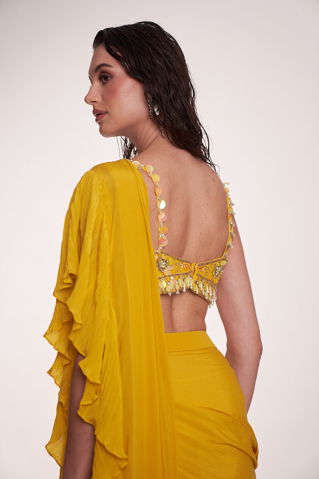 Bright yellow ruffled saree paired with an embellished bralette blouse