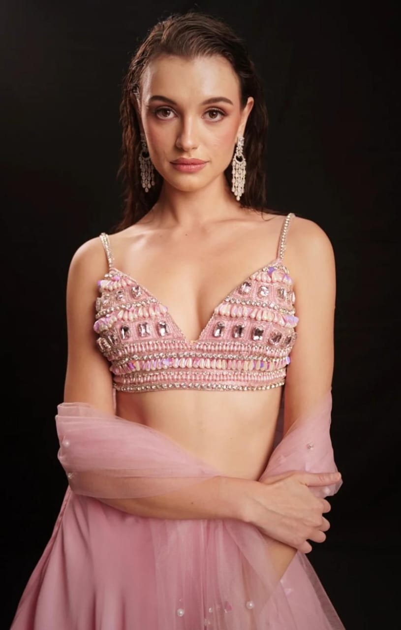 Fresh pink mirror-embellished lehenga with a flowing ruffle-edged skirt and beaded blouse