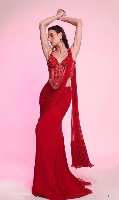 Scarlet red draped saree gown with an intricately embellished corset blouse