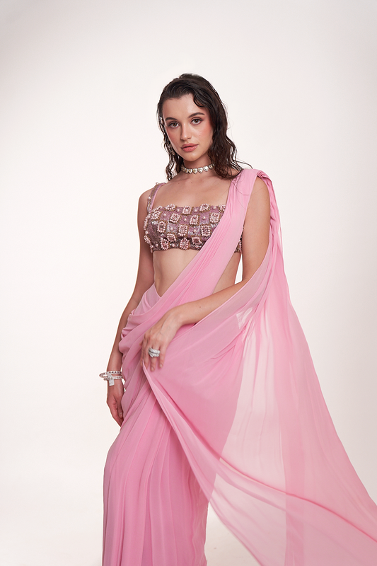 Pastel pink draped saree paired with an intricately embellished mirrorwork blouse
