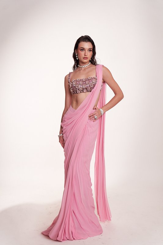 Pastel pink draped saree paired with an intricately embellished mirrorwork blouse