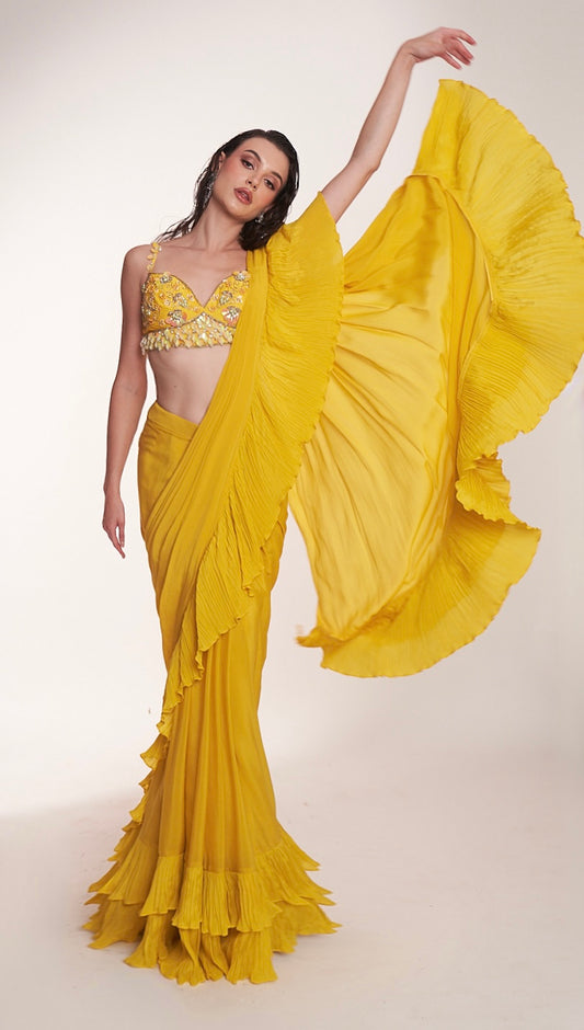 Bright yellow ruffled saree paired with an embellished bralette blouse
