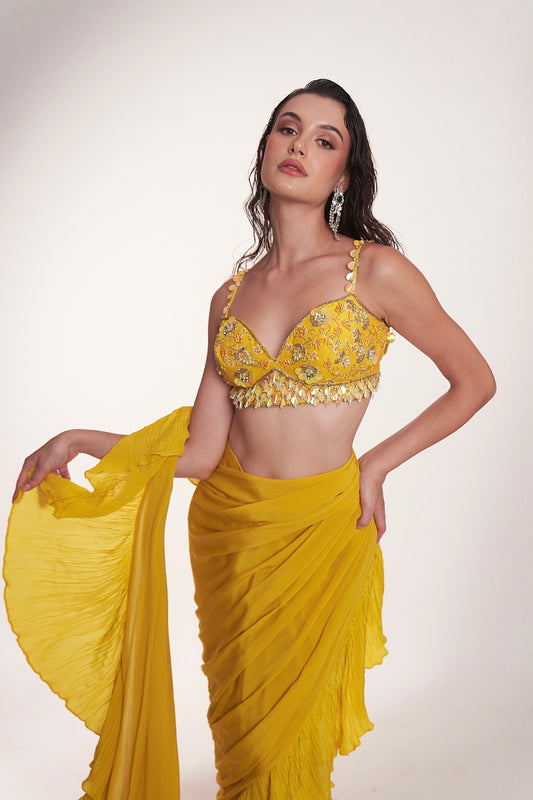 Bright yellow ruffled saree paired with an embellished bralette blouse