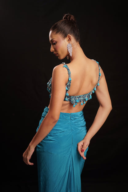 Teal blue embellished one-piece dress with deep V-neck and draped crepe bottom.