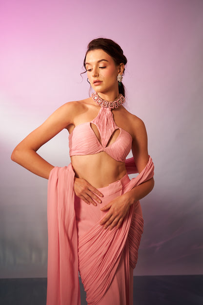 Pastel pink halter blouse with cut-out detail paired with a draped saree