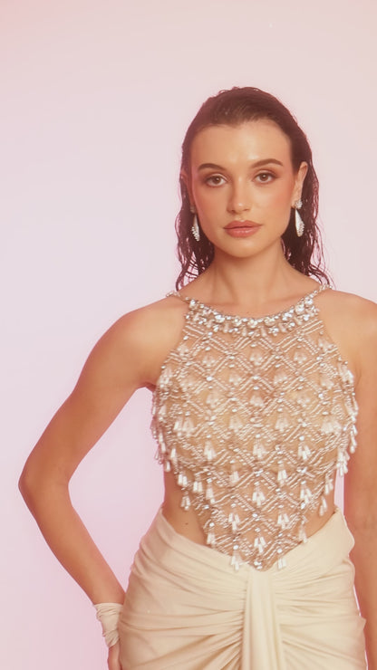 Ivory embellished lycra dress featuring a net halter bodice and draped silhouette